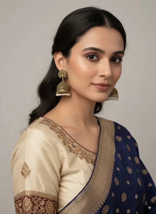 Antique Gold Peacock Jhumka Earrings with Pearl Drops – Traditional Jewellery worn by a model.